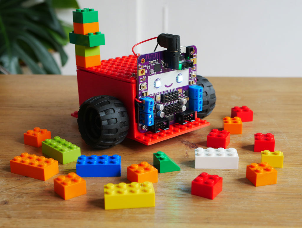 Photo of Smartibot with red body with LEGO type bobbles on top, surrounded by lego bricks.