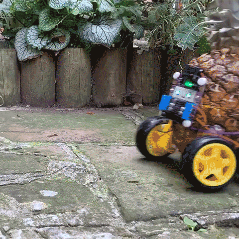 Looping film of a pineapple robot driving into shot and then falling over and disintegrating