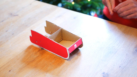 Image of a red sleigh made out of cardboard.
