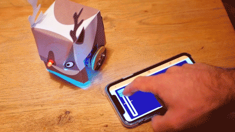 A GIF of a reindeer's red nose being controlled by a control pad on a smartphone.