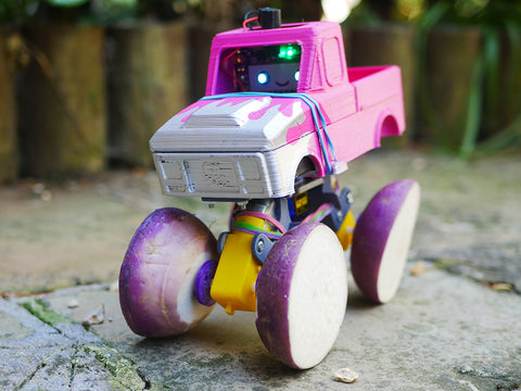 Photo of a pink toy monster truck with each wheel made out of half a turnip