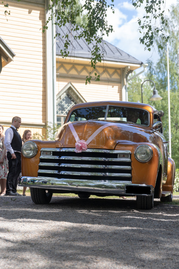 Vanha keltainen vintageauto hääautona