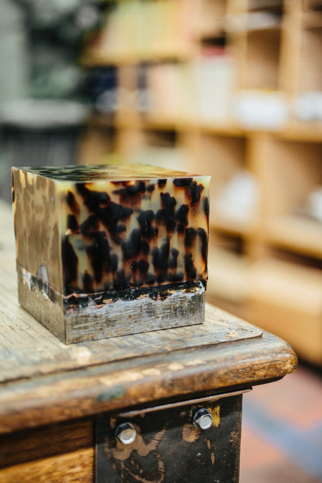 A casted block of tortoise acetate on top of a workbench