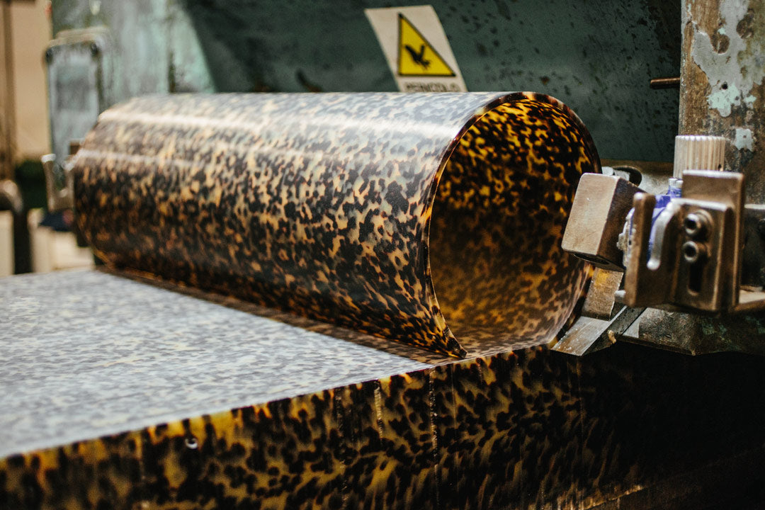 A large sheet or tortoise acetate being sliced into sheets