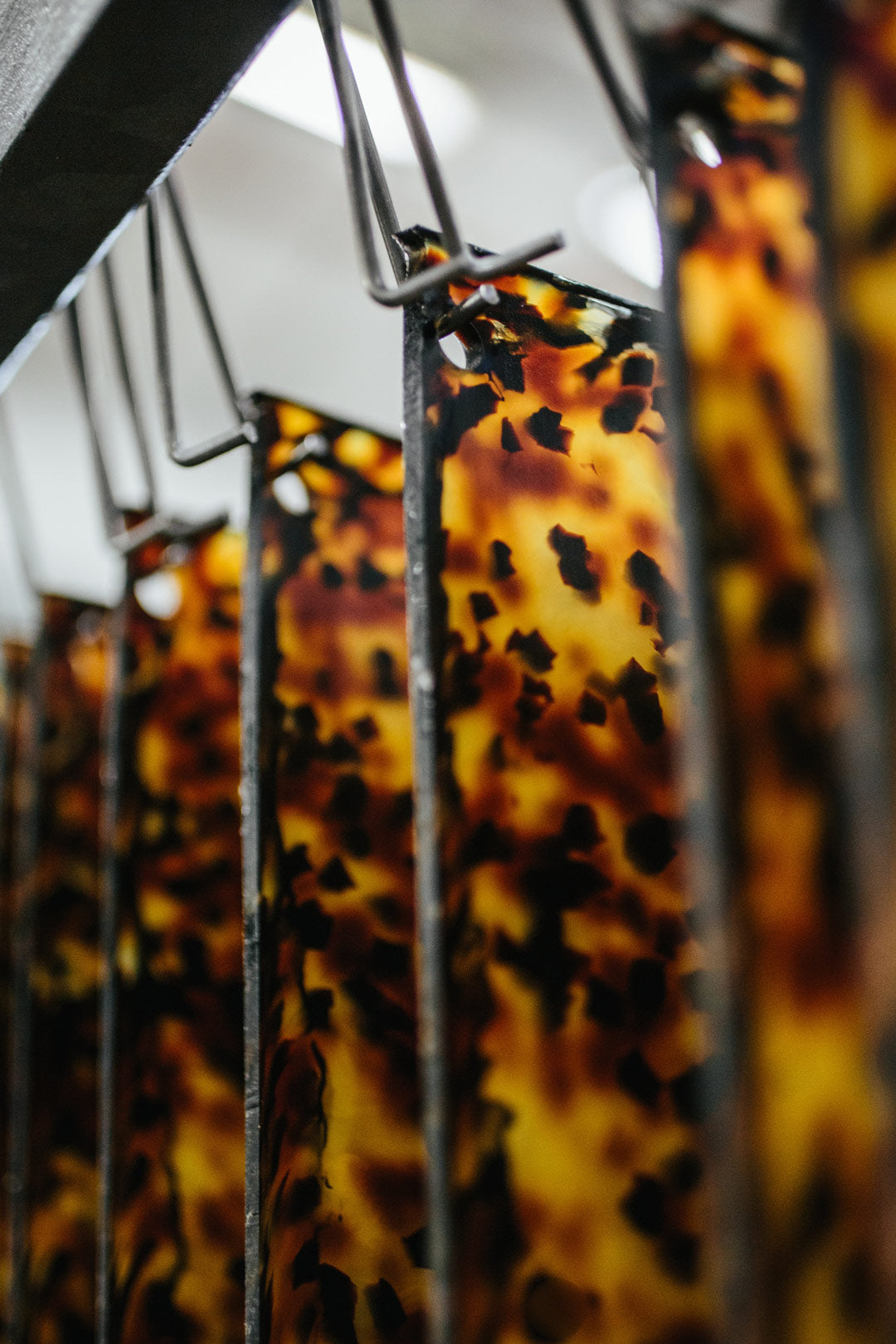 Cellulose acetate sheets hanging from hooks inside a factory