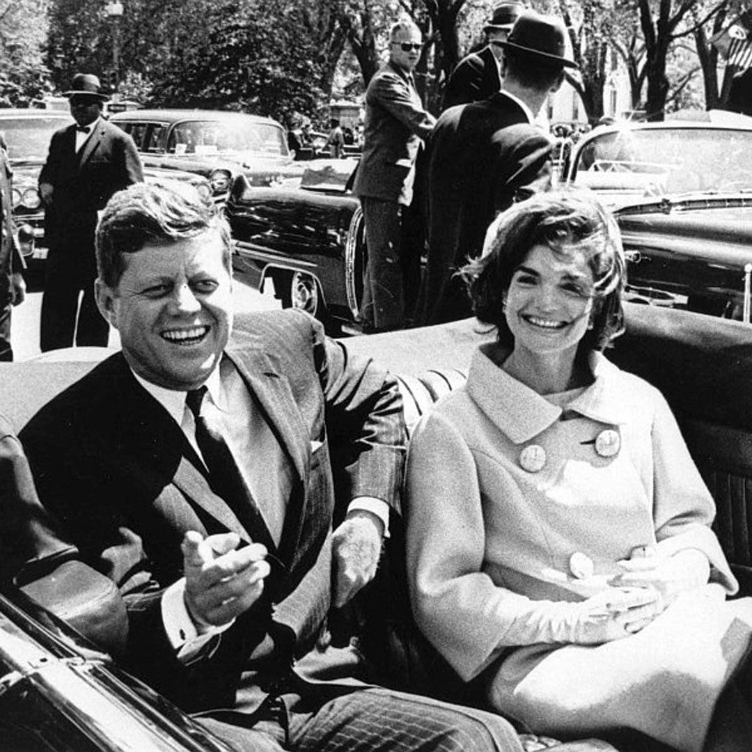 Jackie Kennedy sitting in open top car with her husband JFK
