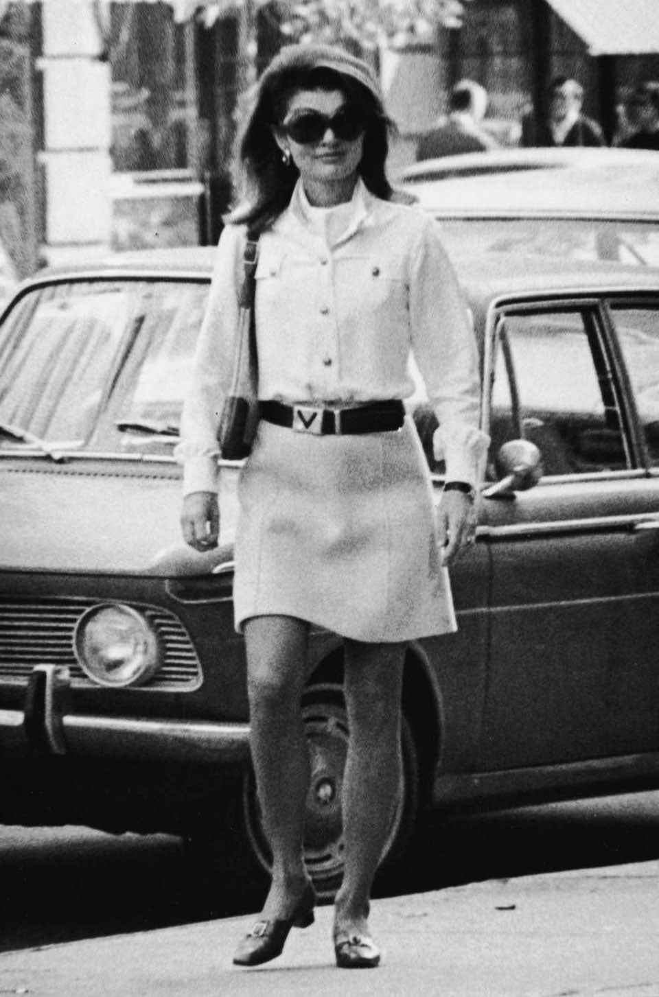 Jackie O in street wearing oversized sunglasses and short skirt