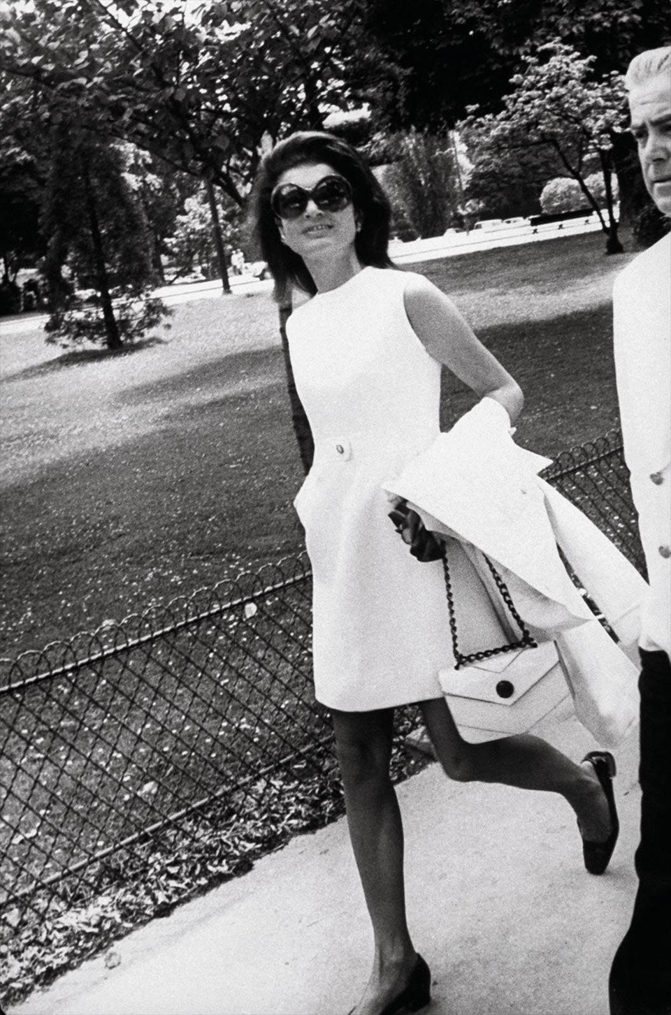 Jackie O wearing sunglasses and plain white dress