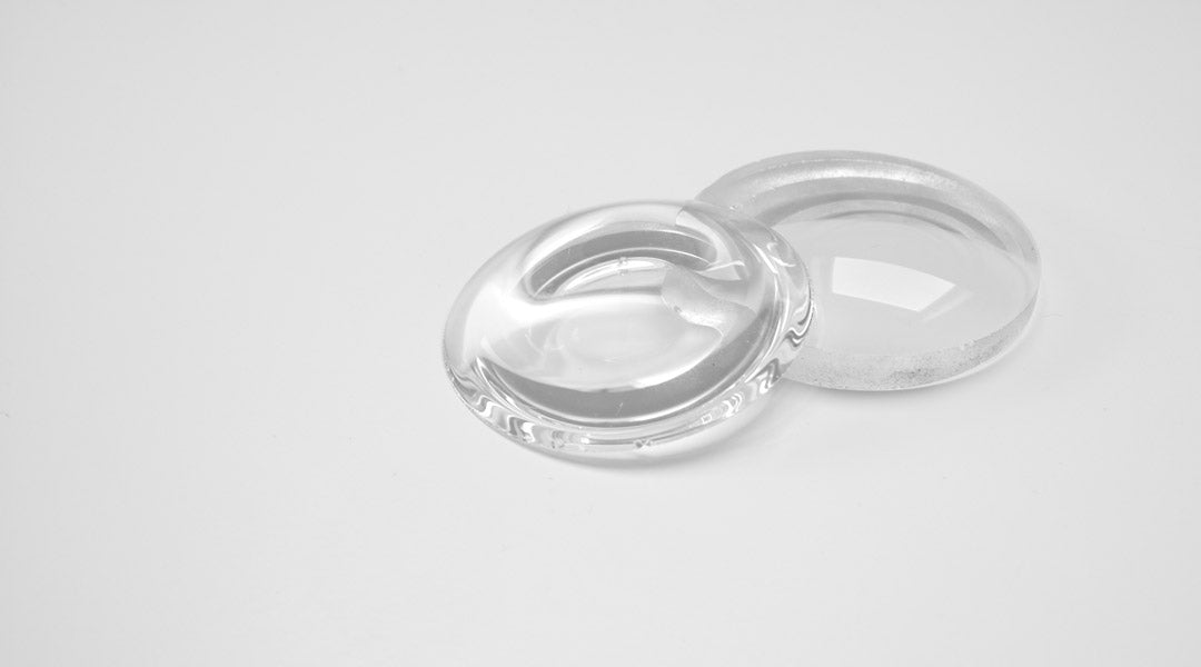 Two glasses lenses on top of each other on a white table