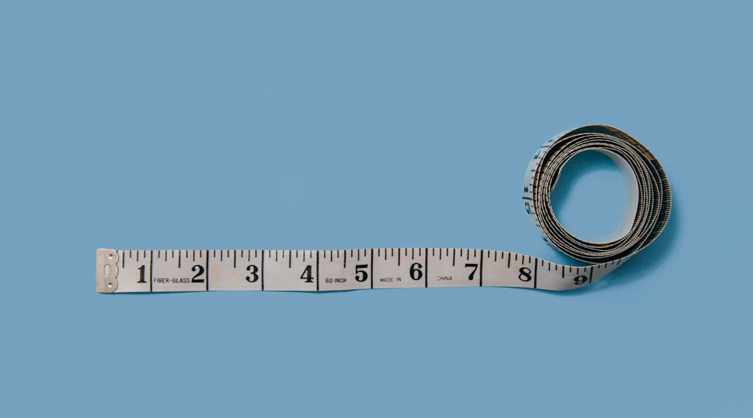 White measuring tape on blue paper background