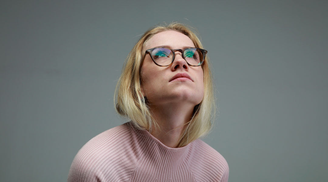 Young blonde woman wearing round tortoise shell glasses