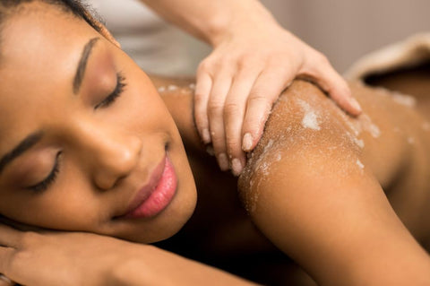 woman receiving a scrub at a spa to treat dead skin