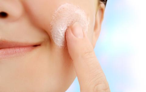 up-close of woman applying cream as part of her decolletage skin care
