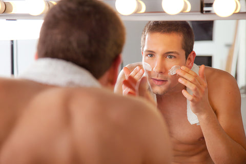 man leaning into mirror while treating men's eye wrinkles