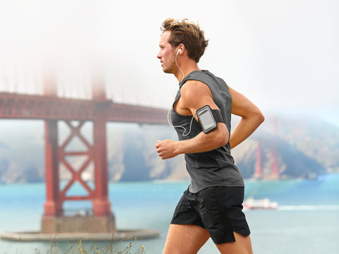 side profile of man running in front of water and bridge