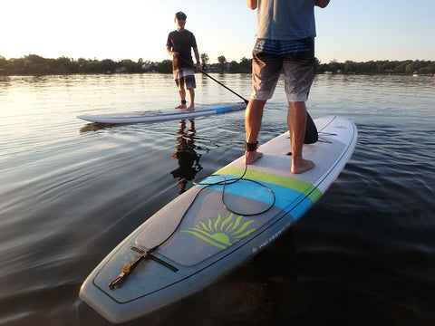 stand up paddle boarders wearing a leashes