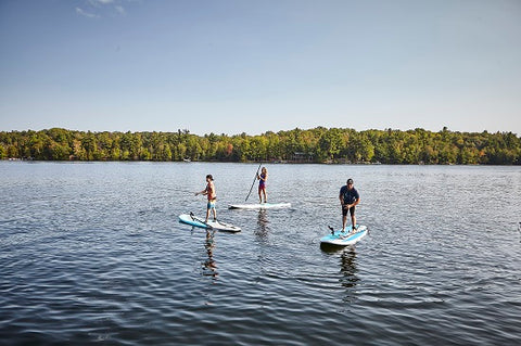 A family stand up paddle boarding on a lake