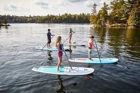 A family stand up paddle boarding