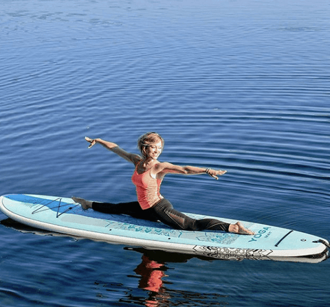 A woman doing stand up paddle board yoga