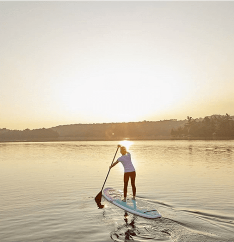 A woman stand up paddle boarding