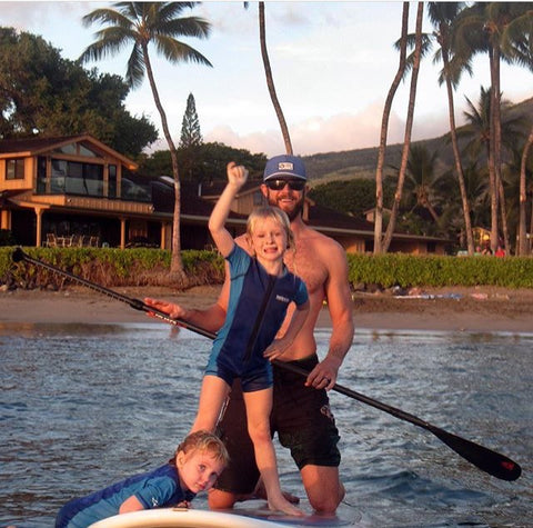 3 people on one stand up paddle board