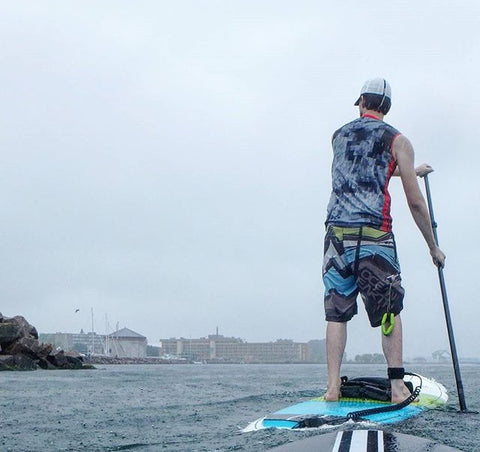 paddle boarding on water near city