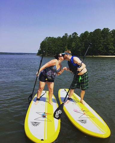 A couple stand up paddle boarding
