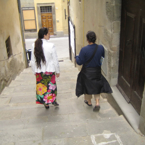 Tuscan Style Home Décor: A Guide The 5 Main Things to Know - A picture of me in Cortona, Italy, chatting with an antique dealer as we head to a warehouse full of Tuscan style treasures.