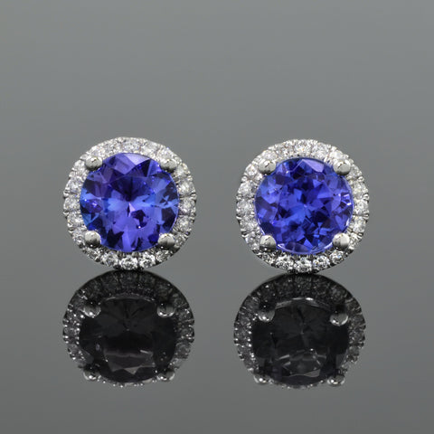  pair of tanzanite stud earrings, each with halo of diamonds.