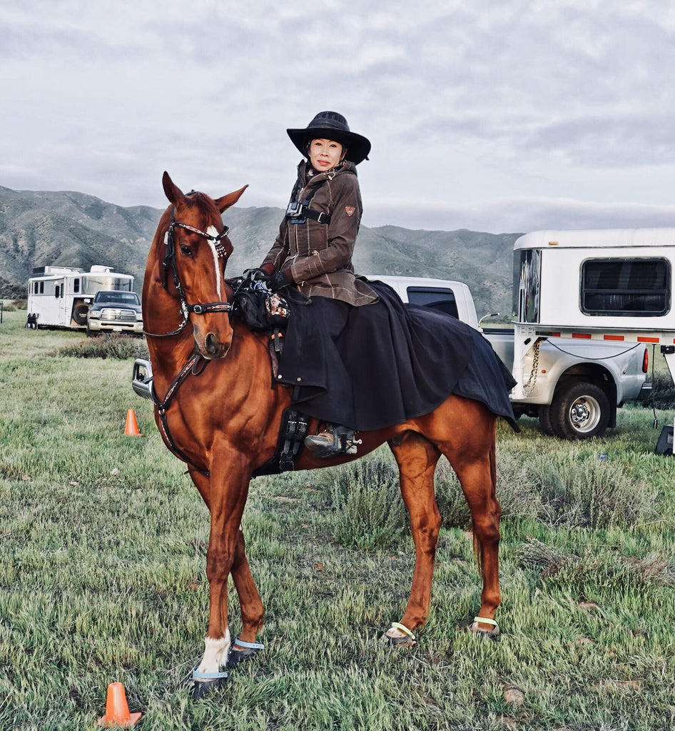 Dawn Champion posing on her brown horse wearing blue Scoot Boots