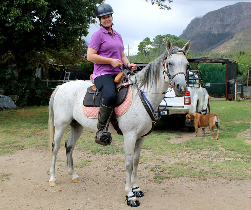 Rider posing on a white horse wearing Scoot Boots