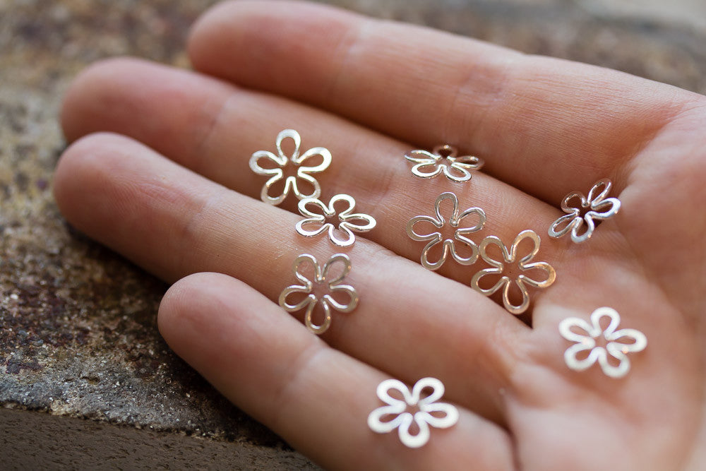 tiny silver wire flower shapes in hand