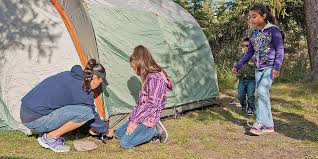 girl helping her mum set up a tent