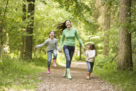 Mother running in the woods with two children