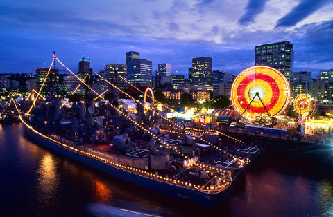 A view of the Portland Rose Festival with a ferris wheel and bustling pier.