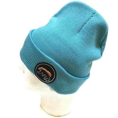 An aqua blue beanie hat, with  a sunset colored griz on the side.