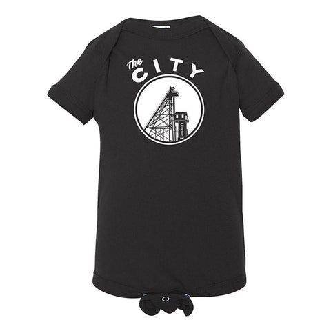 A black onesie for a toddler that says "The City" and has the image of a headframe in a white circle.