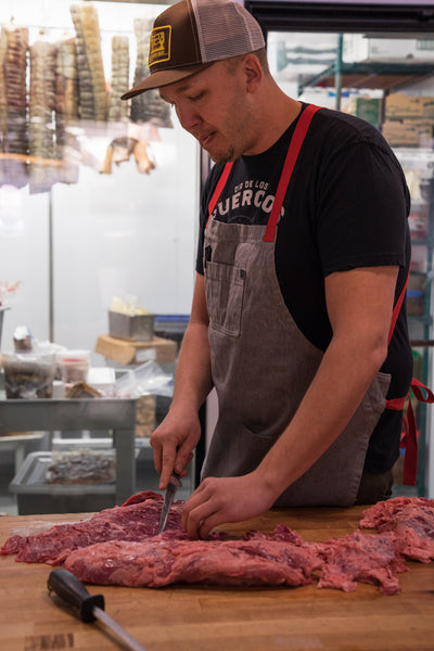 Nate Singer of Blackbelly Market cutting beef