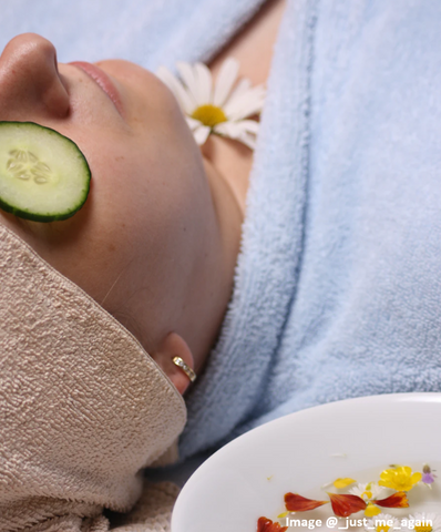woman in a spa with cucumber on her eyes and towels on her head and chest