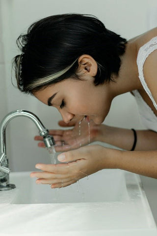 brunette woman washing her face