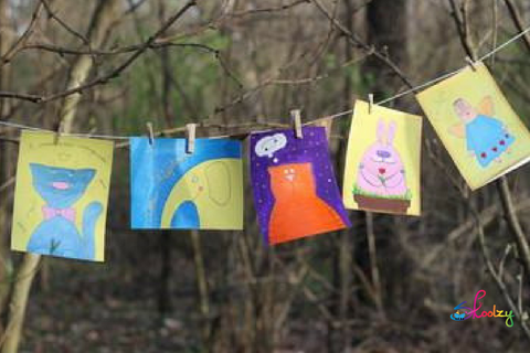 children's pictures hanging by clothespins on a clothes line