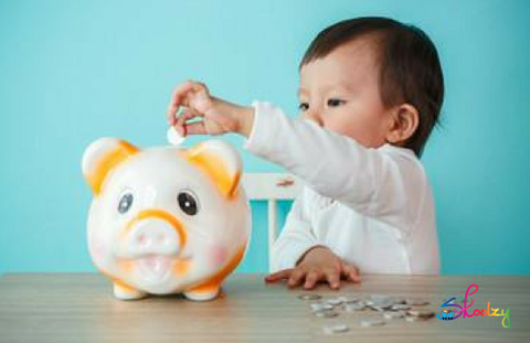 child putting money into a piggy bank