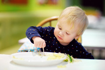 Child using pincer grasp to pick up food
