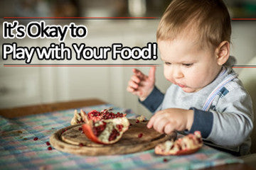 Toddler in high chair eating food with fingers