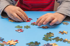 Child putting together a jigsaw puzzle.