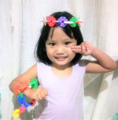 Young girl wearing necklace and bracelet made with Skoolzy products