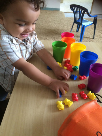 Child sorting bears into sorting cups