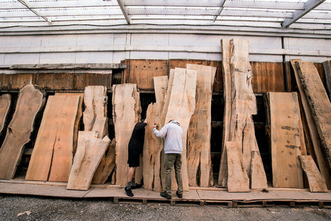 Customers examine a wood slab at Stormo Hardwoods in Everett. They were looking through the inventory for pieces to be made into a coffee table and stand-up table. (Andy Bronson / The Herald)