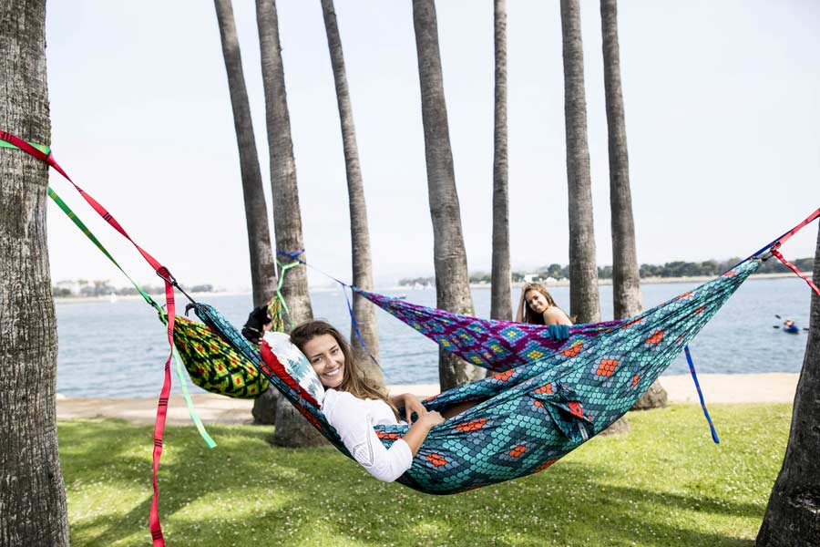 group of girls hammocking by the water and smiling