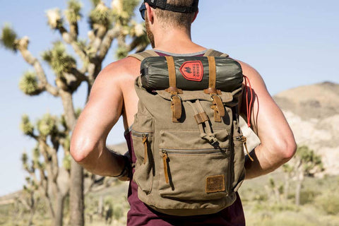 man wearing a brown backpack in the desert